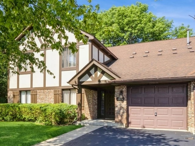 english style home featuring a garage