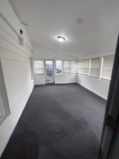 unfurnished sunroom featuring vaulted ceiling