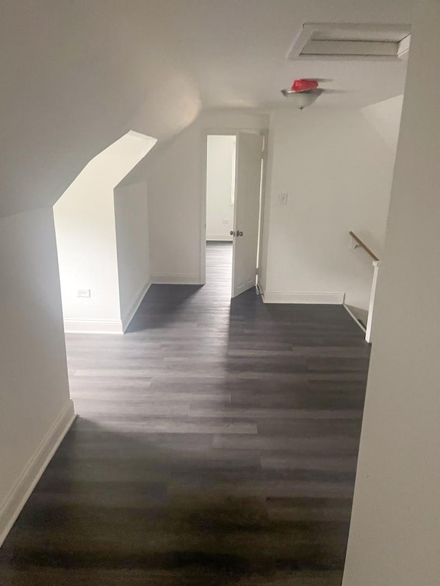 bonus room featuring dark wood-style floors, lofted ceiling, and baseboards