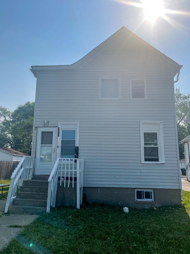 rear view of house with a yard and fence