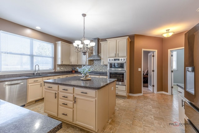 kitchen featuring a center island, pendant lighting, dark countertops, appliances with stainless steel finishes, and a sink