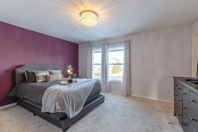 bedroom with light carpet and baseboards