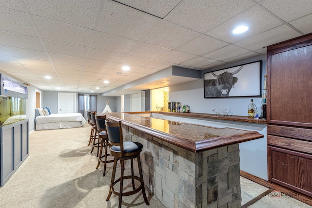 bar with recessed lighting, light carpet, a paneled ceiling, and a bar