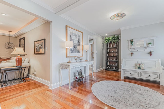 living area featuring baseboards, ornamental molding, and wood finished floors