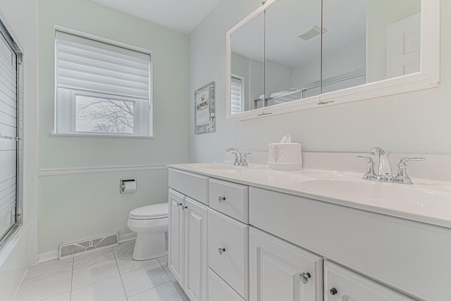 bathroom with enclosed tub / shower combo, toilet, a sink, and visible vents