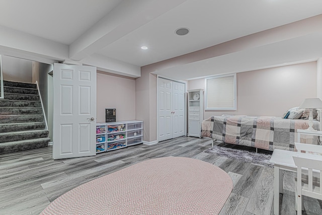 interior space featuring baseboards, wood finished floors, beamed ceiling, a closet, and recessed lighting