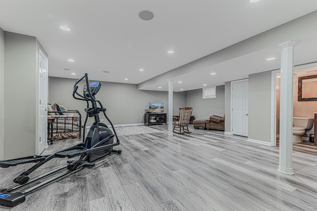 workout room featuring baseboards, decorative columns, light wood-style flooring, and recessed lighting