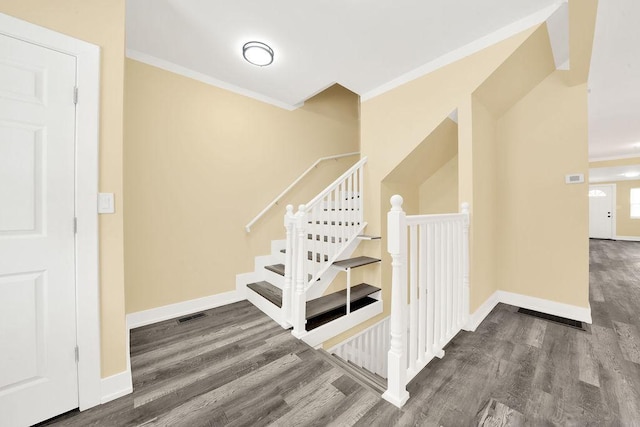 staircase with ornamental molding and wood-type flooring