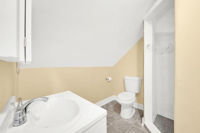 bathroom featuring vaulted ceiling, vanity, a shower, tile patterned flooring, and toilet