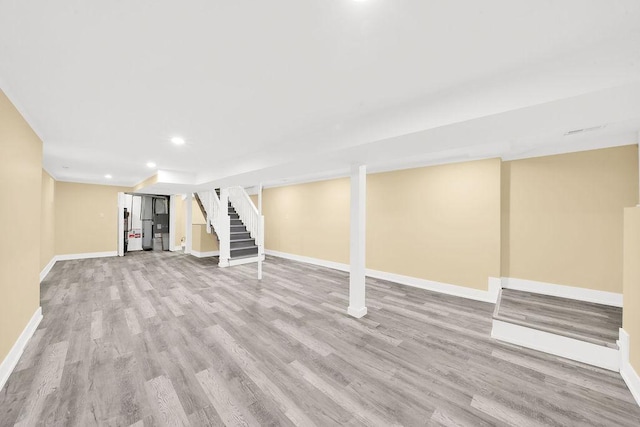 basement with light hardwood / wood-style flooring