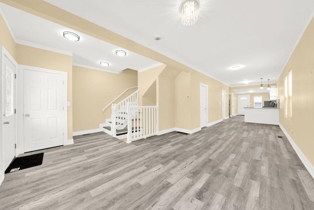 unfurnished living room with light hardwood / wood-style floors and ornamental molding