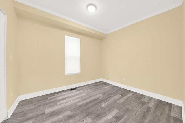 spare room featuring hardwood / wood-style floors and crown molding