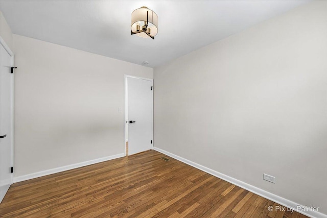 empty room featuring baseboards and wood finished floors