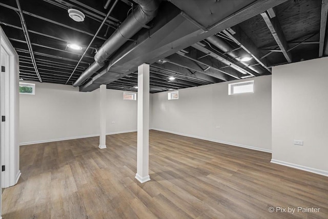 basement with baseboards and wood finished floors