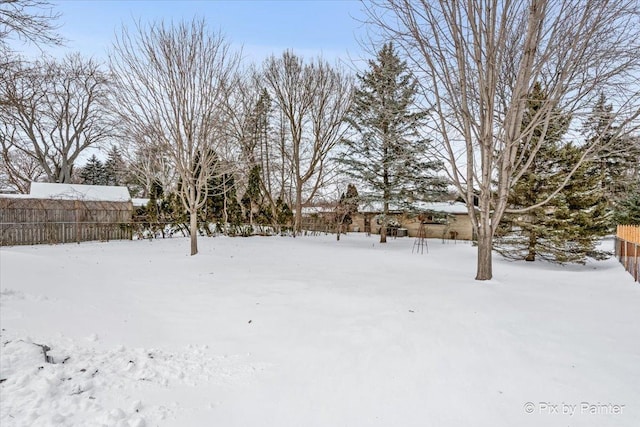 snowy yard featuring fence