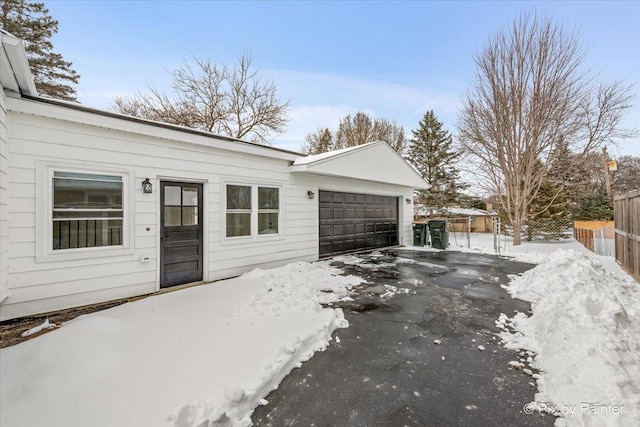 exterior space with a garage, driveway, and fence