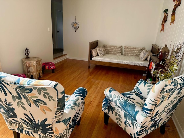 living area with baseboards and wood finished floors