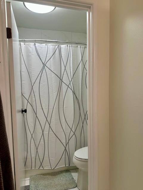 full bath featuring tile patterned floors, toilet, and a shower with shower curtain