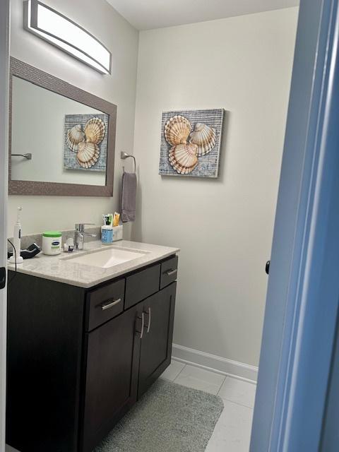 bathroom featuring baseboards, tile patterned floors, and vanity