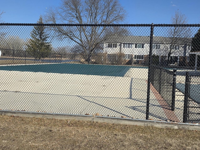 view of tennis court featuring fence