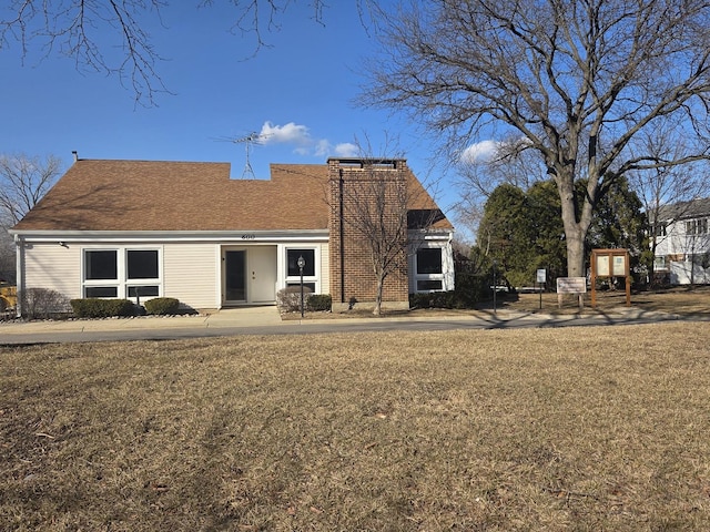 view of front of property featuring a chimney and a front lawn