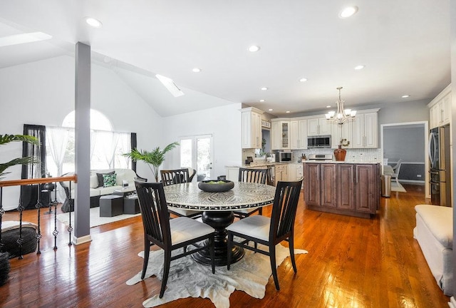 3642 Monarch Cir, Naperville, IL 60564 - dining area featuring an inviting chandelier, vaulted ceiling with skylight, dark wood-style flooring, and recessed lighting