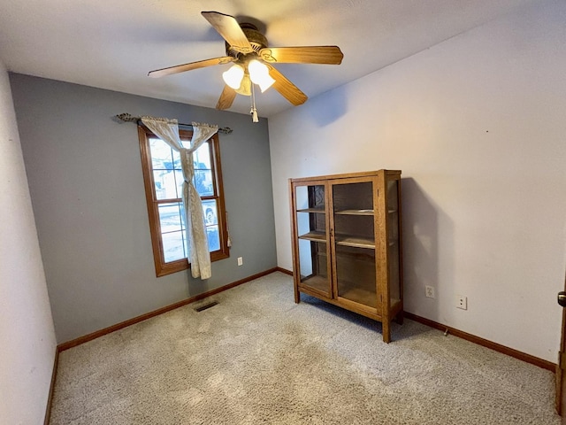 unfurnished room with baseboards, visible vents, ceiling fan, and light colored carpet