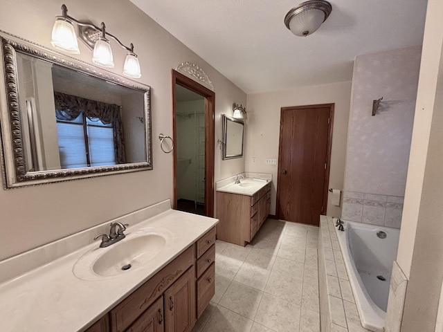 bathroom featuring a garden tub, two vanities, a sink, and tile patterned flooring