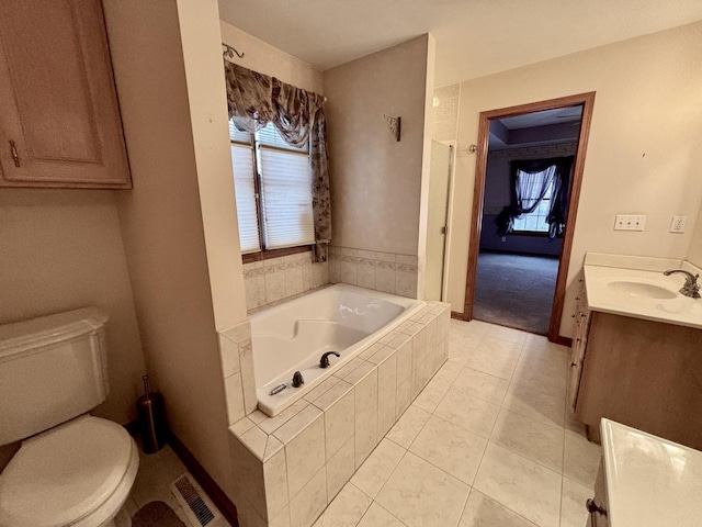 bathroom with a bath, plenty of natural light, vanity, and visible vents