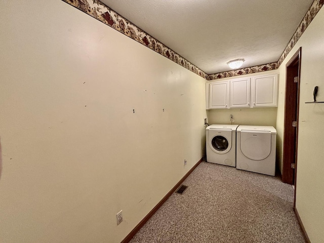 laundry area featuring cabinet space, visible vents, baseboards, washing machine and clothes dryer, and a textured ceiling