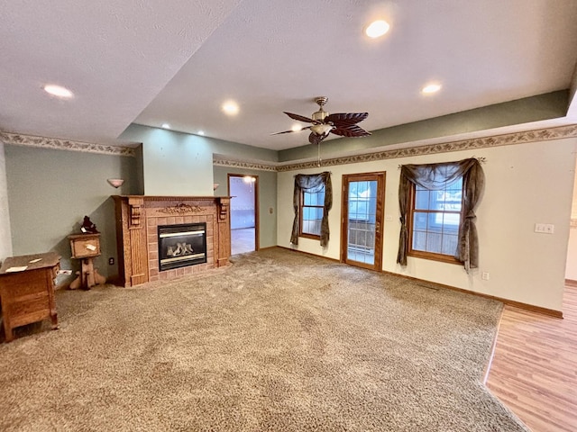 unfurnished living room featuring baseboards, a ceiling fan, a textured ceiling, a fireplace, and recessed lighting