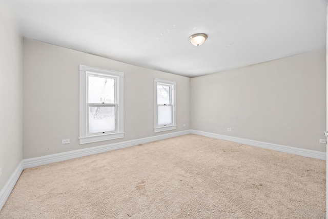 unfurnished room with carpet flooring and baseboards