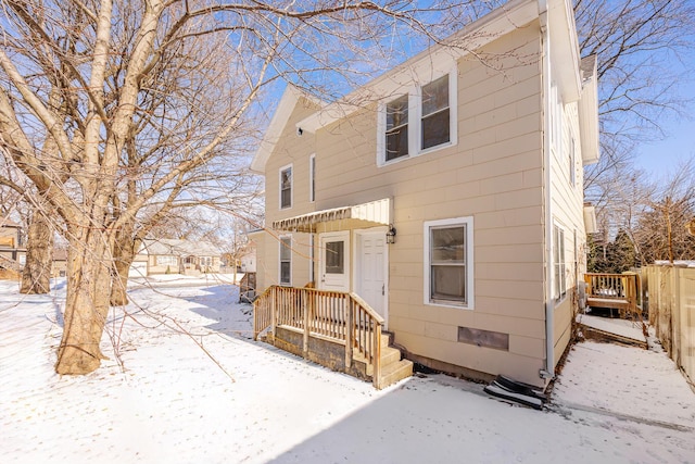 snow covered property with fence