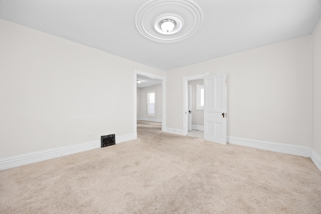 carpeted spare room featuring visible vents and baseboards