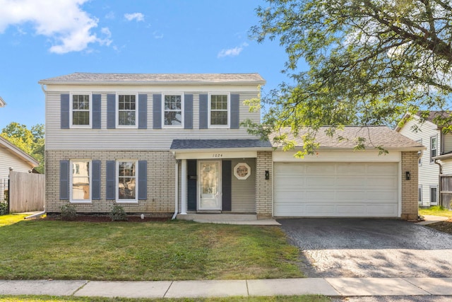 view of front facade with a garage, a front yard, brick siding, and driveway