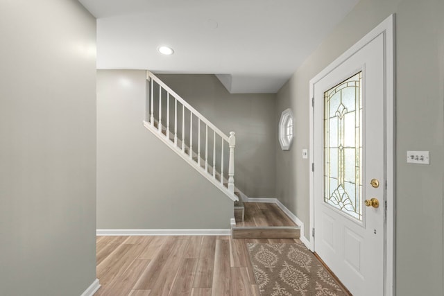 foyer with light wood-style flooring, stairway, baseboards, and recessed lighting