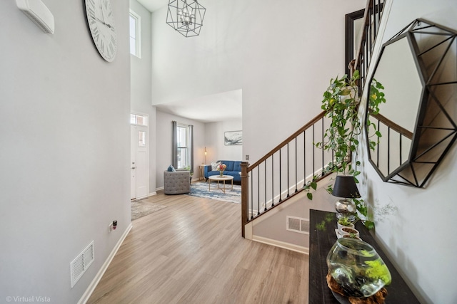 entryway featuring light wood-style flooring, stairs, visible vents, and baseboards