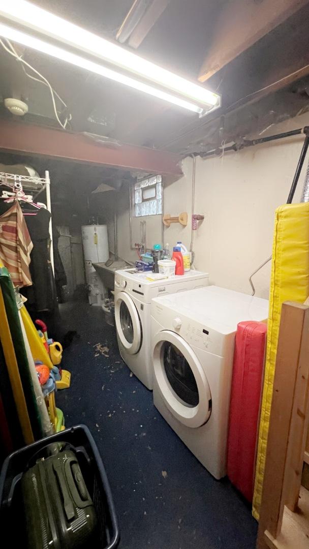 laundry room featuring water heater and washer and clothes dryer