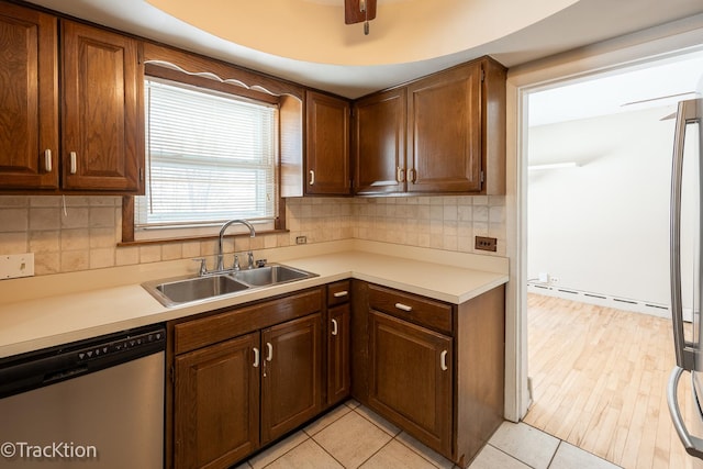 kitchen with baseboard heating, sink, stainless steel dishwasher, ceiling fan, and decorative backsplash
