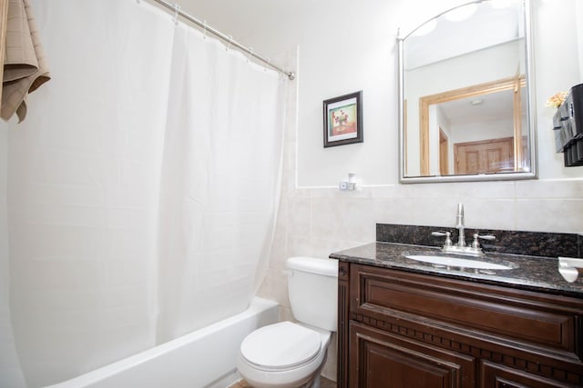 bathroom featuring vanity, toilet, tile walls, and shower / tub combo