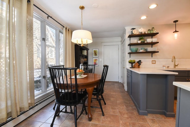 dining space with crown molding, sink, and a baseboard radiator