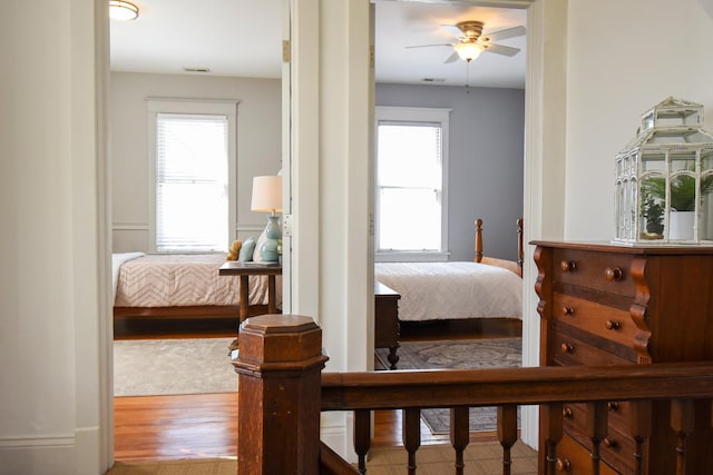 bedroom with multiple windows and hardwood / wood-style flooring