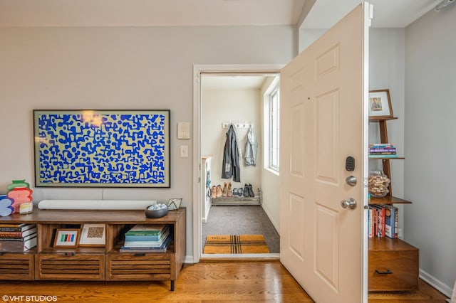 foyer featuring baseboards and wood finished floors