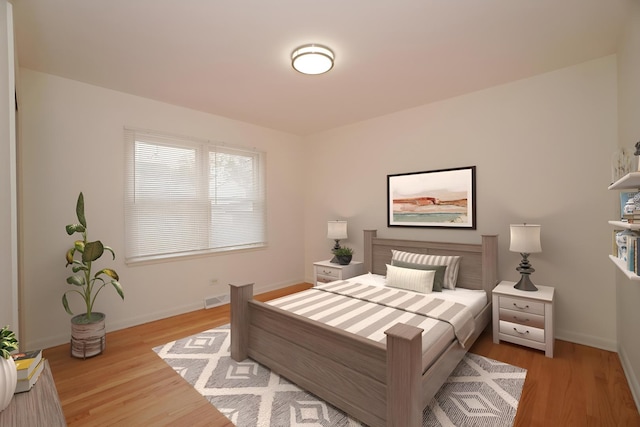 bedroom with light wood-style floors, visible vents, and baseboards
