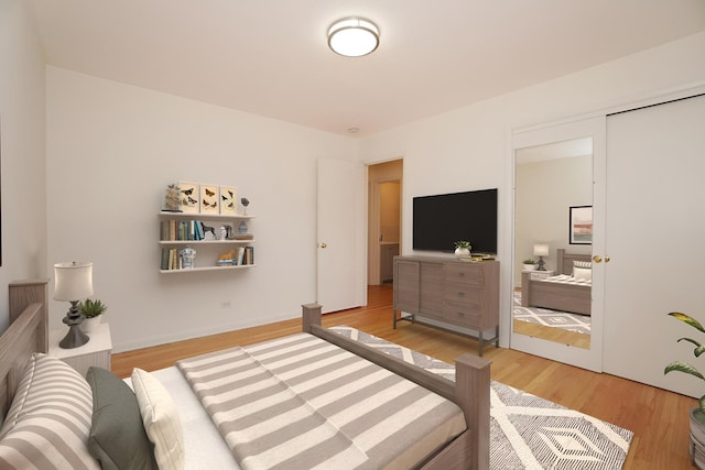 bedroom featuring light wood finished floors and baseboards