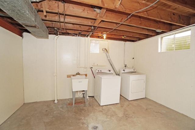 clothes washing area with laundry area, separate washer and dryer, and a sink