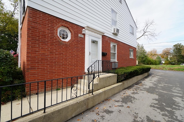 view of exterior entry featuring brick siding