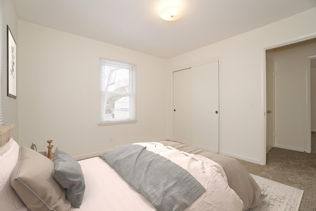 carpeted bedroom with baseboards and a closet