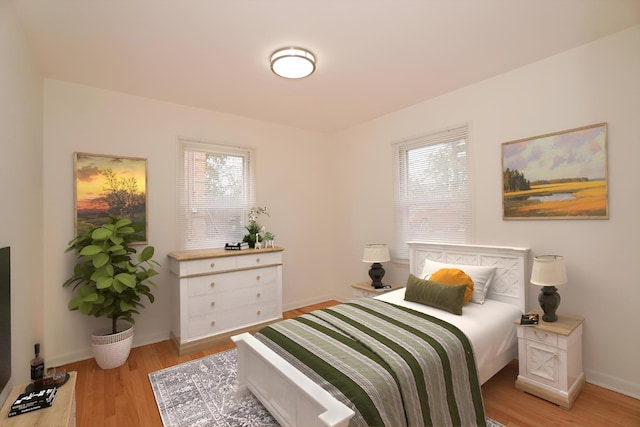 bedroom with light wood finished floors and baseboards