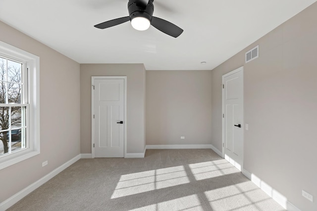 unfurnished bedroom featuring ceiling fan and light colored carpet